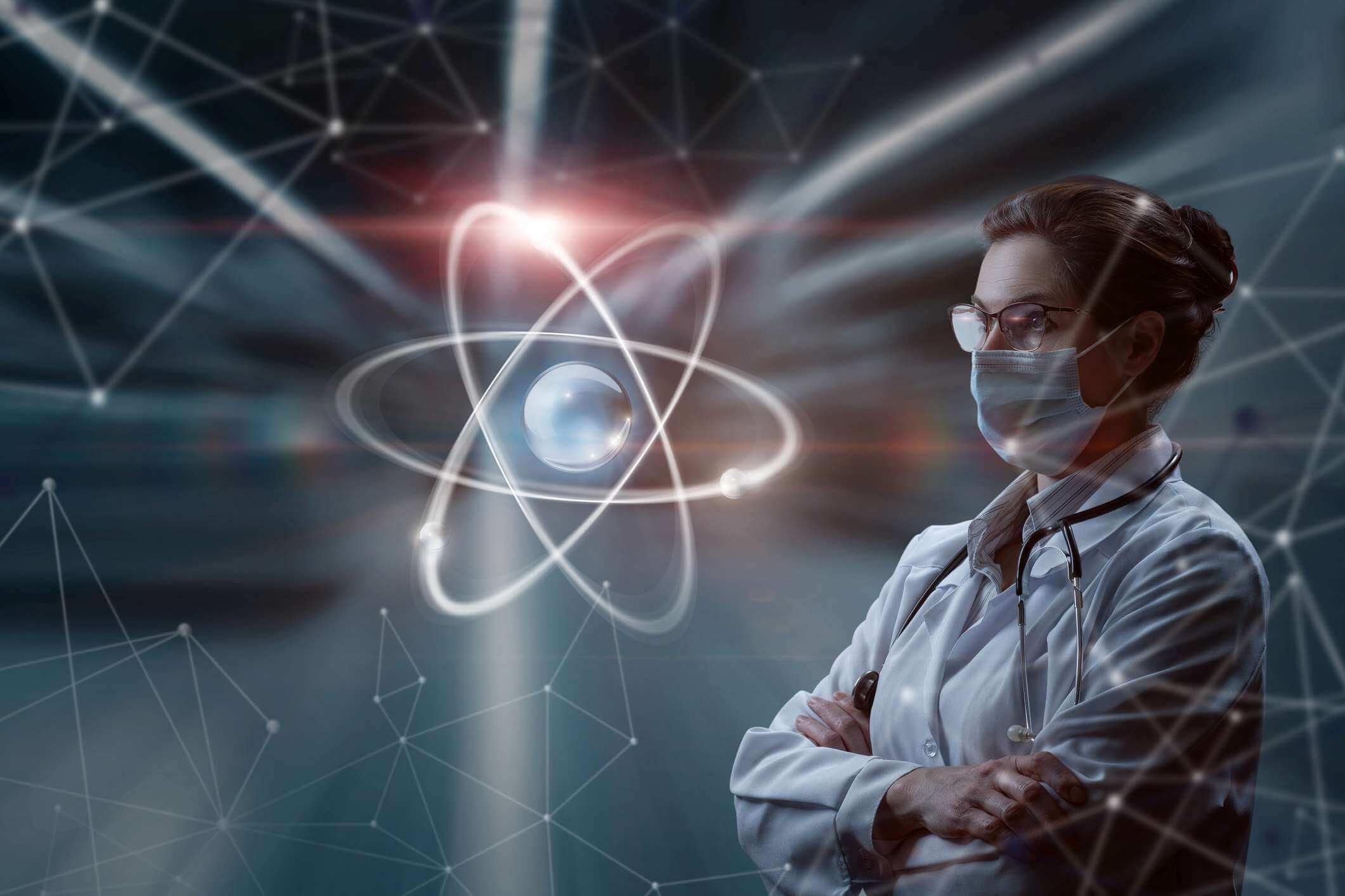 Eine Frau in einer Maske in Uniform betrachtet ein Atom auf einem verschwommenen Hintergrund.