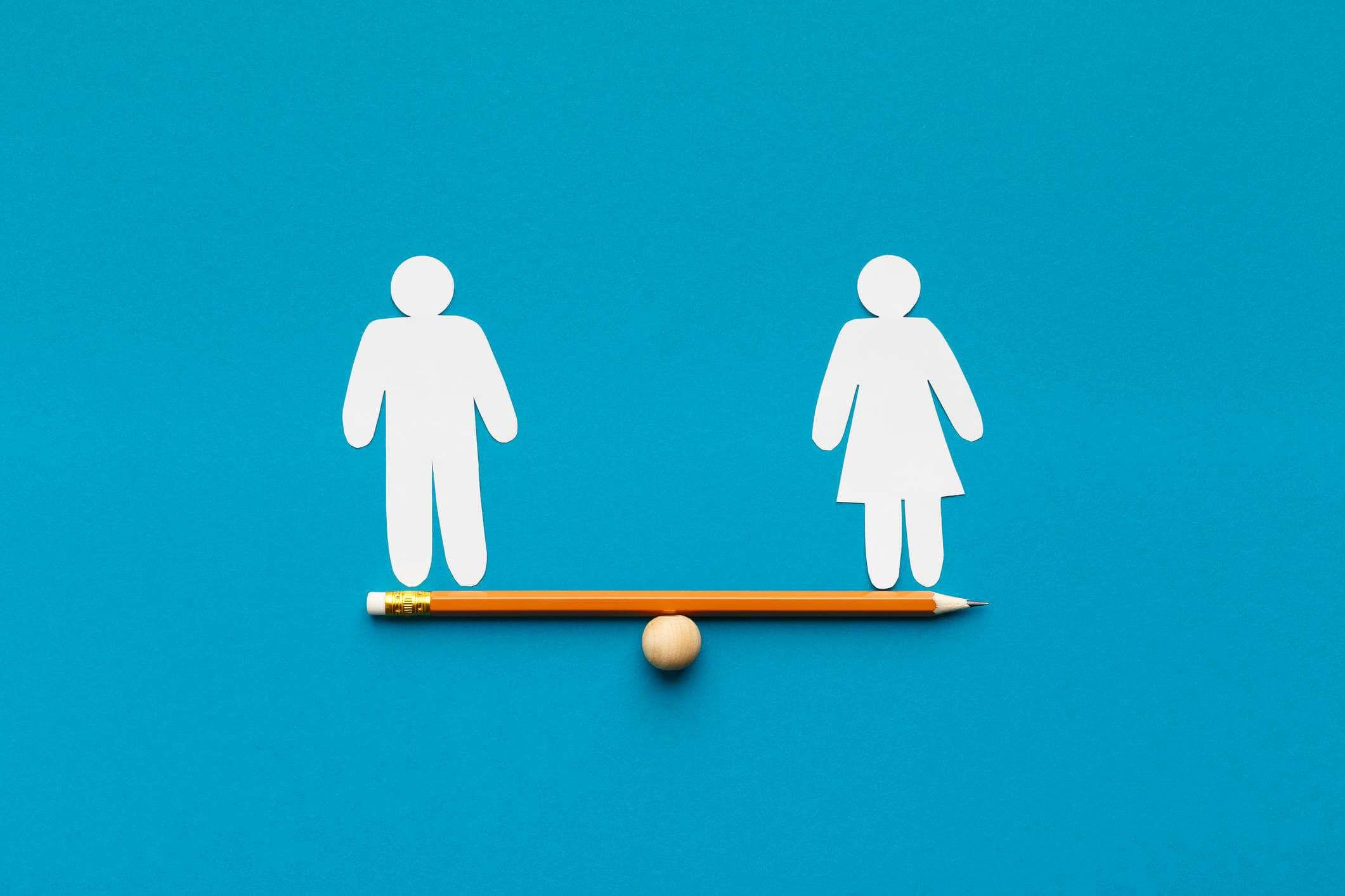 Geschlechtergleichstellung in der Unternehmenswelt. Figuren von Mann und Frau auf Bleistiftwippe, blauer Hintergrund, Kopierraum