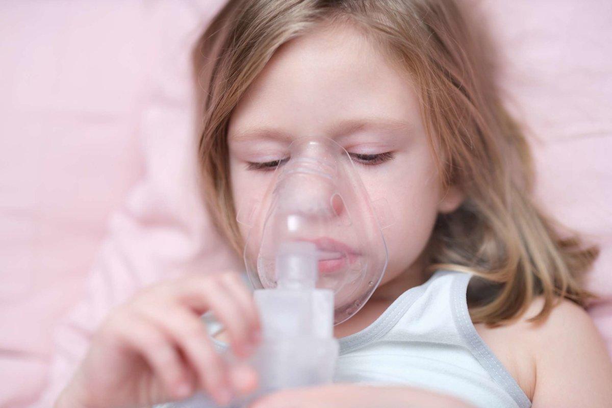 Kleines Mädchen inhaliert Medikamente zur Hustenbehandlung. Konzept zur Behandlung von Asthma bronchiale bei Kindern