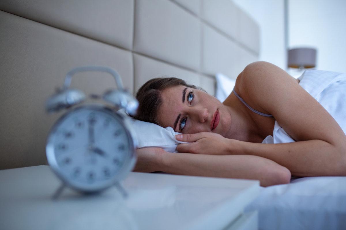 Frau mit Schlaflosigkeit liegt mit offenen Augen im Bett. Mädchen im Bett leidet unter Schlaflosigkeit und Schlafstörungen und denkt nachts über sein Problem nach