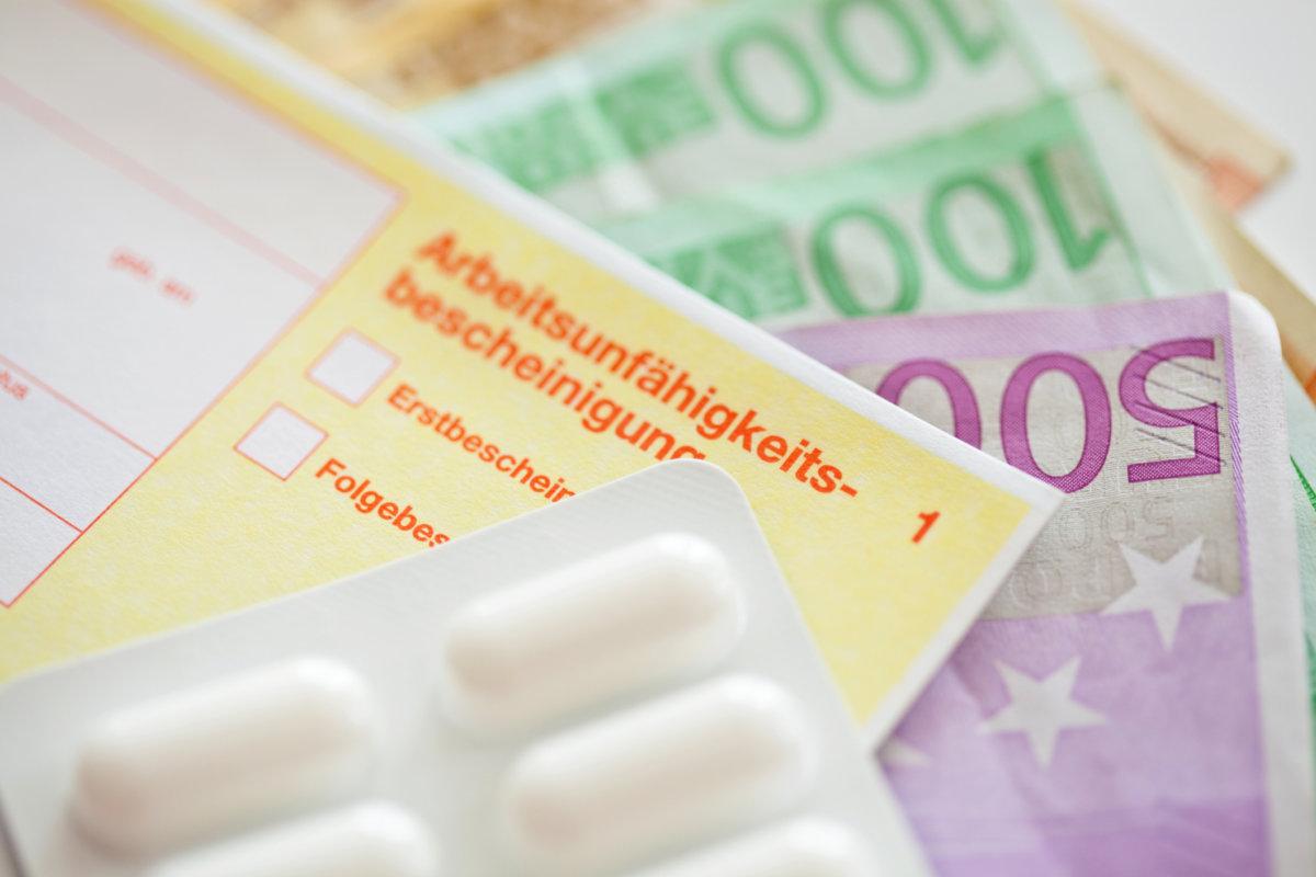 Nahaufnahme eines deutschen Papiers für die Krankenversicherung im Krankheitsfall mit Euro-Banknoten