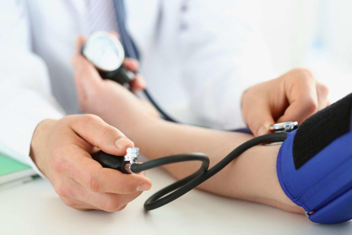 Der Arzt überprüft den Blutdruck des Patienten in der Klinik, das Risiko von Bluthochdruck und beugt Krankheiten vor