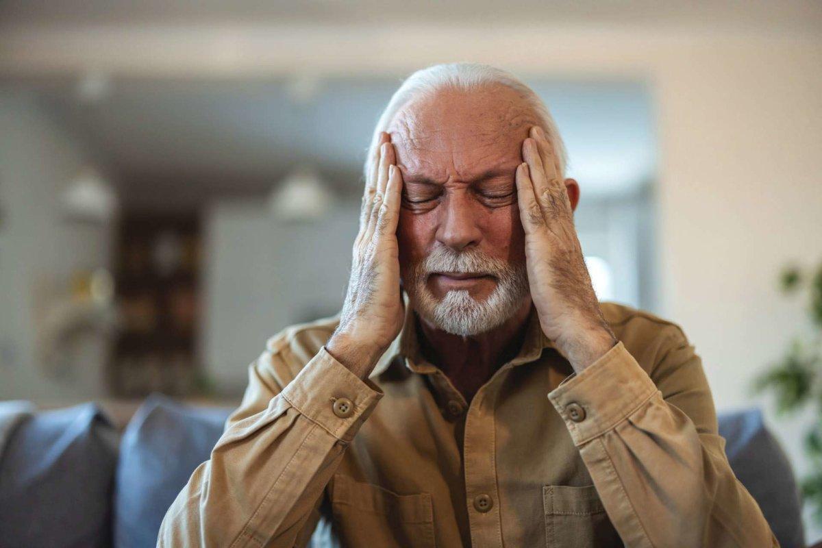 Shot of a senior man suffering from a headache at home. Unpleasa