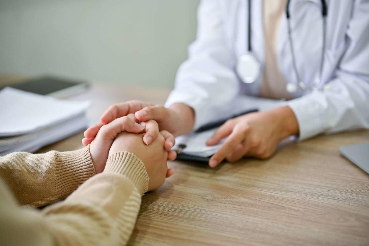 Close up view of doctor touching patient hand, showing empty and kindness. Health care concept