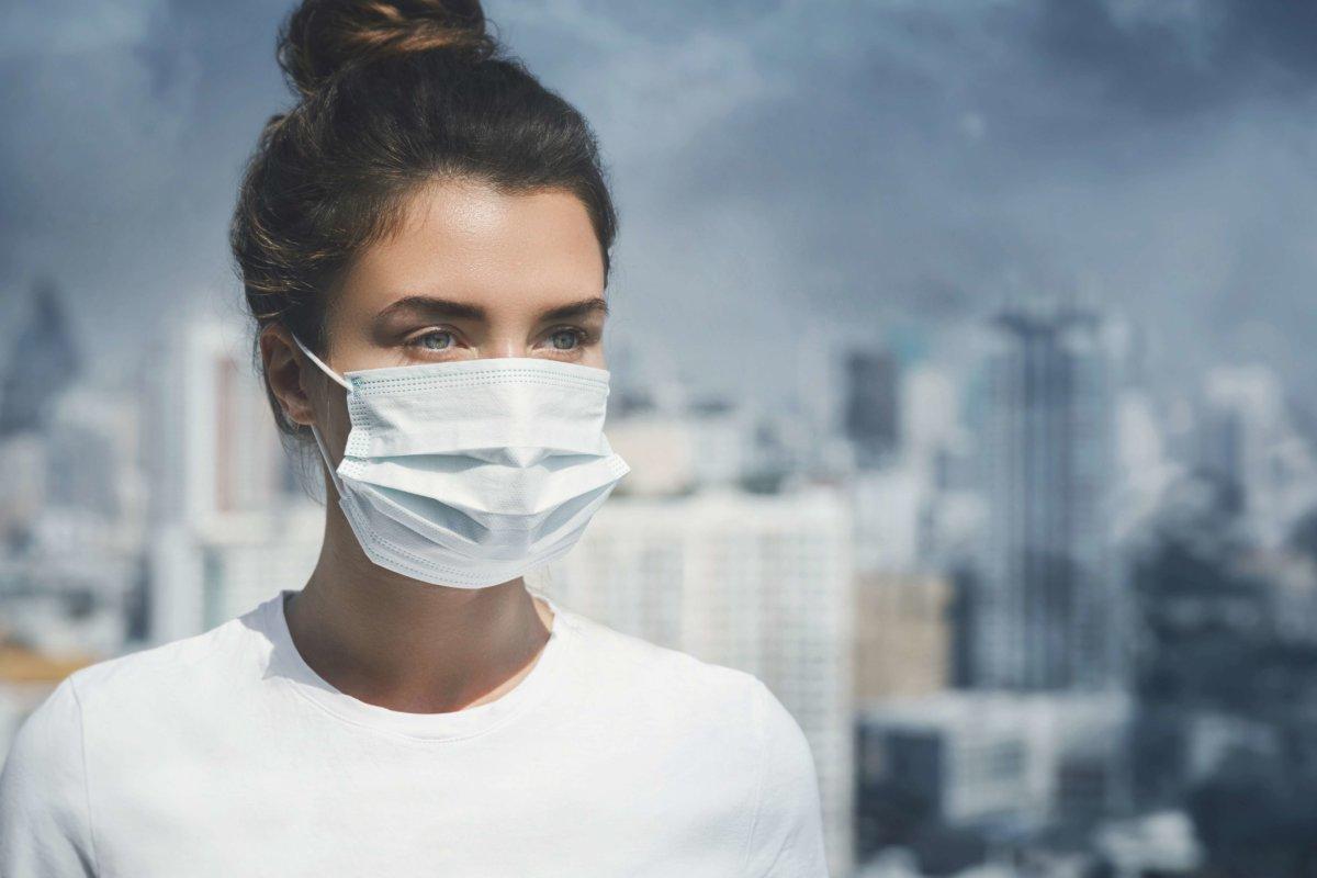 Woman wearing face mask because of air pollution in the city