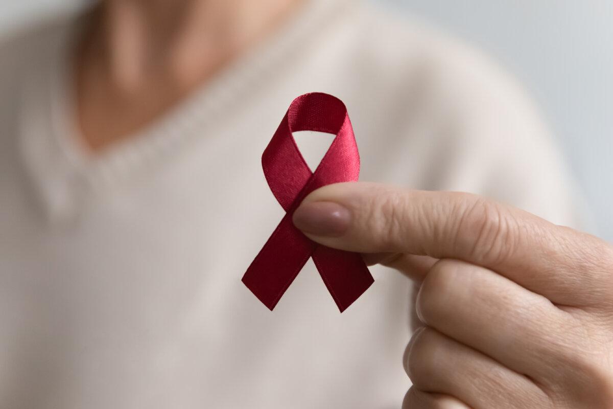 Dame zeigt HIV- oder Aids-Bewusstseinssymbol und engagiert sich ehrenamtlich für wohltätige Zwecke