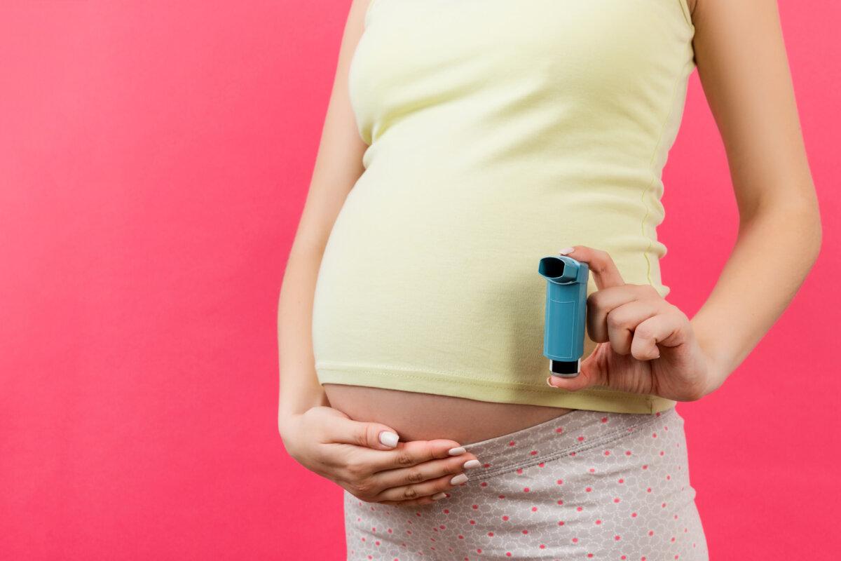 Abgeschnittenes Bild einer schwangeren Frau, die Asthma-Inhalator hält, um Anfällen vor buntem Hintergrund mit Kopierraum