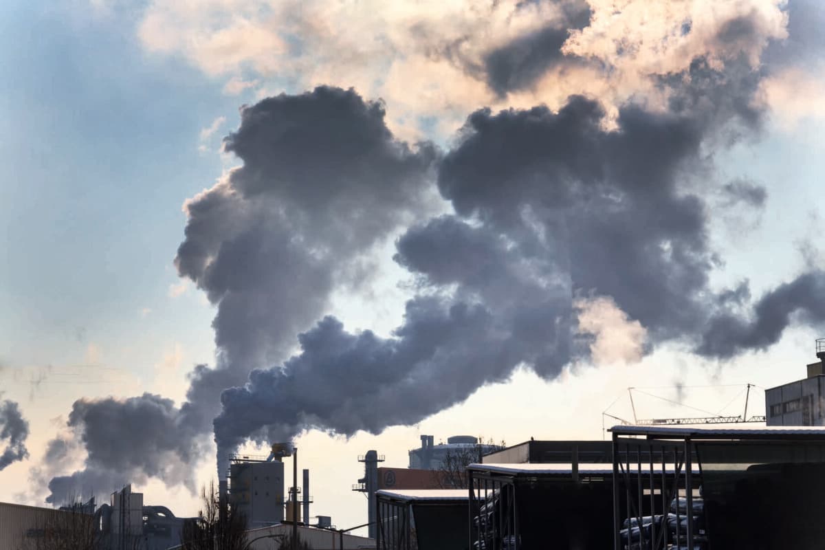 Schlot eines Industriebetriebes mit Rauch. Symbolfoto für Umweltschutz und Ozon.