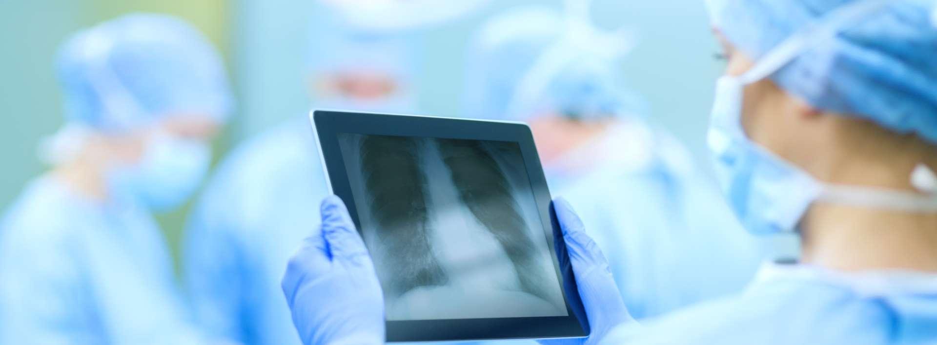 Chirurg, der Röntgen auf Tablet-Computer im Operationssaal untersucht